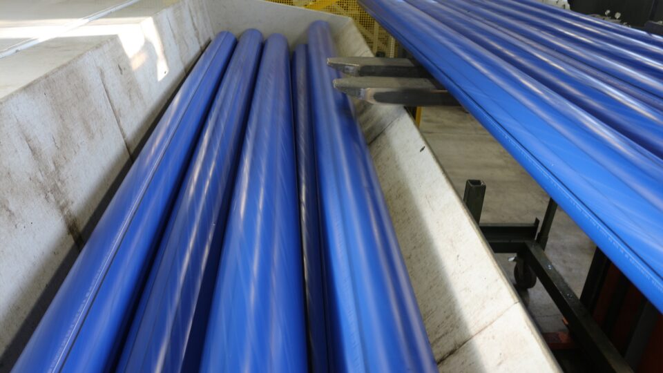 A forklift loads PE pipes into the receptacle of the S:GRAN